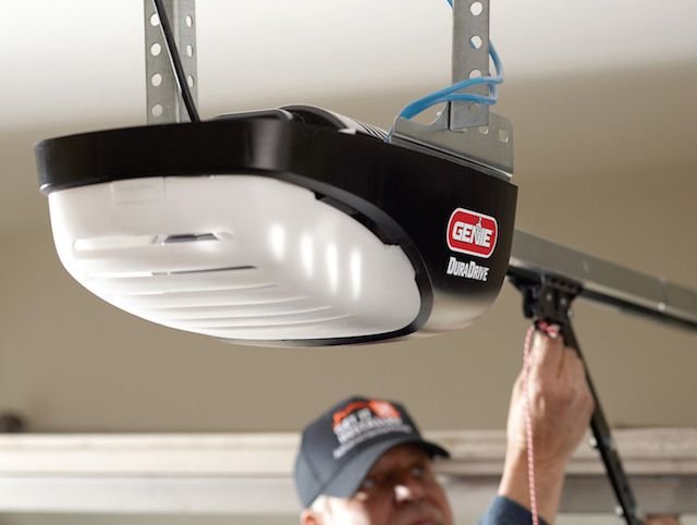 Professional installing a Genie garage door opener in a garage