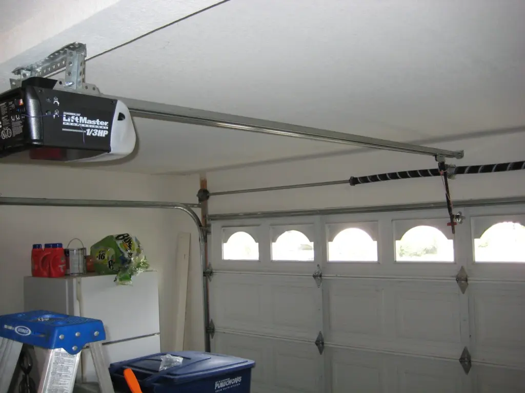 LiftMaster garage door opener mounted on the ceiling in a clean, organized garage with a tool setup.